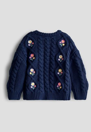 Suéter de punto con trenzas en color navy, adornado con bordados florales en paneles de rombos texturizados. Cuello redondo y fabricado con un tejido grueso y acogedor.