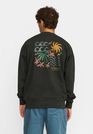 Sweat-shirt noir avec un graphisme coloré au dos représentant des vagues, des palmiers et un soleil. Détails aux poignets et à l'ourlet côtelés.