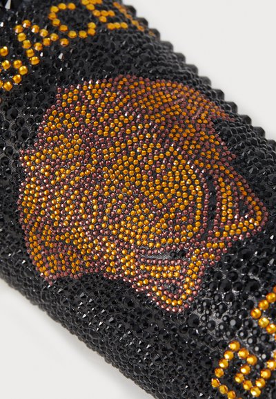 Black material adorned with a textured pattern of orange, yellow, and burgundy rhinestones forming a lion's head design.