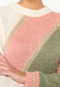 Mjuk stickad tröja med diagonala färgblock i kräm, rosa och grön, med detaljer i guld och ribbad halsringning och ärmmuddar.