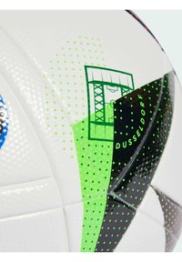 Biely futbalový lopta s textúrovaným povrchom, na ktorom sú zelené a čierne geometrické vzory. Obsahuje grafiku štadióna a text "DUSSELDORF."