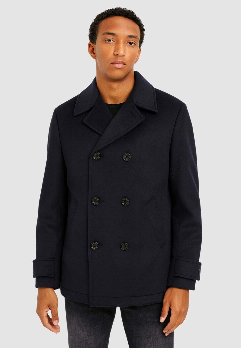 Cappotto peacoat doppiopetto blu navy realizzato in una miscela di lana, con grandi bottoni neri e tasche laterali, colletto a revers e maniche lunghe.