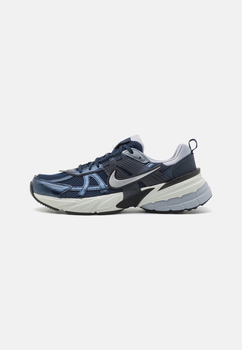 Námořnické modré sportovní tenisky s horní částí z úpletu a syntetického materiálu, obsahující stříbrný swoosh, polstrovanou podrážku a černé a šedé akcenty.