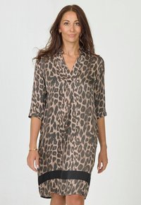 Leopardprint jurk met V-hals, driekwart mouwen en zwarte zoomaccenten. Gemaakt van lichte stof met een zachte textuur.