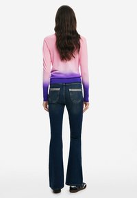 Kohandatud roosa-lilla ombre särk pikkade varrukatega, koos tumedate siniste laienevate teksadega, mis on varustatud tagakottide ja denimi tekstuuriga.