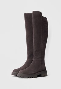 Ciemnoszare botki zamszowe sięgające do kolan, z płaską, wytrzymałą podeszwą i niewielką platformą; cechują się minimalnym przeszyciem i małym logo.