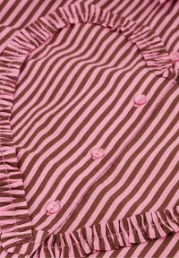 Bruin en roze gestreepte stof met een hartvormige halslijn, voorzien van ruches en bijpassende roze knopen langs de voorkant.