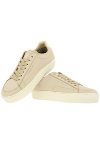 Beige leren sneakers met een gladde textuur, ronde neus, platte veters en een contrasterende witte rubberen zool; minimalistisch ontwerp met subtiele stiksels.