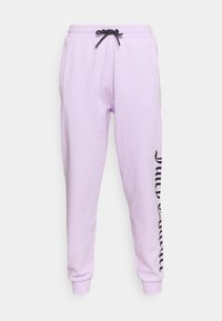 Fialové tepláky vyrobené z měkkého materiálu, s černou šňůrkou a bočními kapsami. Černý text podél jedné nohavice dodává detail.