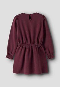 Robe bordeaux avec de longues manches bouffantes, taille élastique et fermeture par un motif en trou de serrure au dos. Le matériau présente un léger motif texturé avec des filaments.
