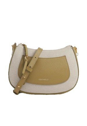 Petit sac bandoulière en tissu beige avec poche avant en cuir vert olive, sangle réglable, accessoires dorés et fermeture éclair.