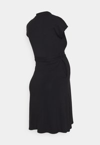 Vestido preto com mangas curtas estilo cap, corpete ajustado e detalhe na cintura atado. Saia evasé que cai até a metade da panturrilha, textura de tecido suave.