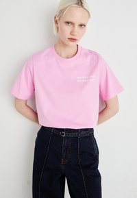 Camiseta de algodón rosa con mangas cortas y cuello redondo, que presenta la frase "ENCONTRARÁS EL CAMINO CORRECTO" en texto blanco en la parte delantera.