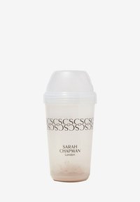 Transparenter Plastik-Shaker mit weißem Deckel, gefüllt mit einem beigen Pulver. Bedruckter Text lautet "SARAH CHAPMAN London" und wiederholtes Logo.
