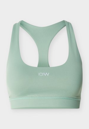 Lys grønn sømløs sports-BH med racerback-design og hvit "ICIW"-logo midt foran.