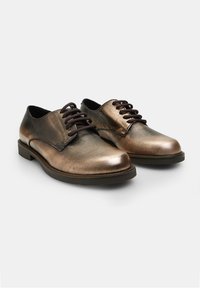Scarpe in pelle bronzo con superficie liscia, punta arrotondata e lacci marroni scuri. Presentano un tacco basso a blocco e un design minimal.