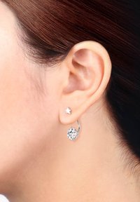 Boucle d'oreille en argent avec un accent en cristal clair et une petite étoile en stud. Fini lisse et texture polie. Convient à diverses occasions.