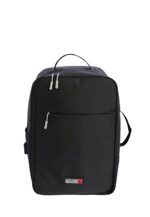 Mochila de tela negra con forma rectangular, que cuenta con dos tiradores de cremallera plateados, un bolsillo frontal y un asa superior. Logo en la parte inferior.