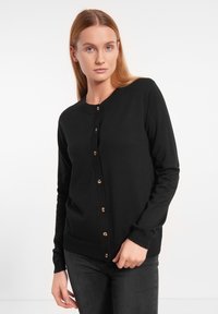 Schwarze Strickjacke aus weichem Stoff, mit rundem Halsausschnitt, langen Ärmeln und goldenen Knopfverschlüssen auf der Vorderseite.