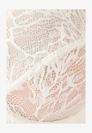 Sujetador de encaje blanco con un patrón floral, textura de malla suave y un delicado ribete a lo largo de las costuras, resaltando detalles intrincados.