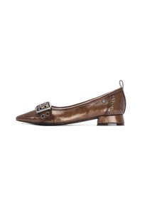 Zapato plano de cuero charol marrón con punta afilada, detalle de hebilla plateada y pequeño tacón cuadrado; cuenta con acentos metálicos decorativos en el costado.