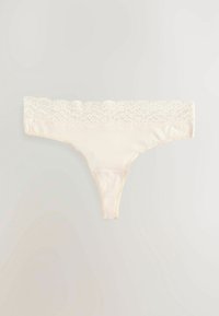 Beige string met een brede kanten tailleband, zachte stof en minimale bedekking. Het kant heeft een geschulpte rand.