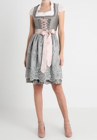 Tradycyjna szara dirndl z misternym haftem kwiatowym, koronkowym wykończeniem i różową satynową kokardą, z dopasowaną górą i rozkloszowaną spódnicą.