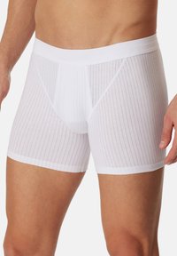Boxer da uomo bianchi realizzati in cotone rigato. Presentano un morbido elastico in vita e una vestibilità aderente con texture a righe verticali.