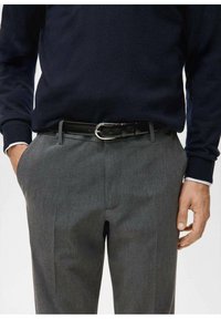 Gray trousers made of textured fabric, featuring a flat front and side pockets. A black leather belt with a silver buckle secures the waistband.