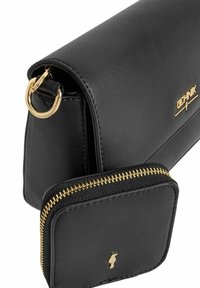 Czarna skórzana torebka o gładkiej fakturze, z dodatkami w kolorze złotym oraz pasującą małą saszetką na zamek, przymocowaną do torebki.