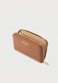 Portofel maro din piele ecologică cu marcaj auriu, închidere cu fermoar și interior bej. Prezintă o textură netedă și o formă rectangulară subțire.