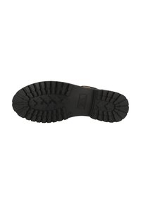 Suela de goma negra con un patrón de relieve profundo, que presenta formas cruzadas elevadas y un detalle de marca en el centro. Diseñada para ofrecer tracción y estabilidad.