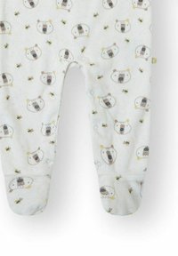 Pijama con pies de tela blanca con un patrón de osos y abejas. Textura suave con cierres a presión en la parte frontal y los pies.