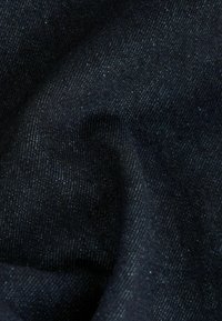 Tela de mezclilla oscura, que presenta una textura suave con un ligero brillo. El tejido muestra patrones diagonales ajustados en tonos de azul profundo.