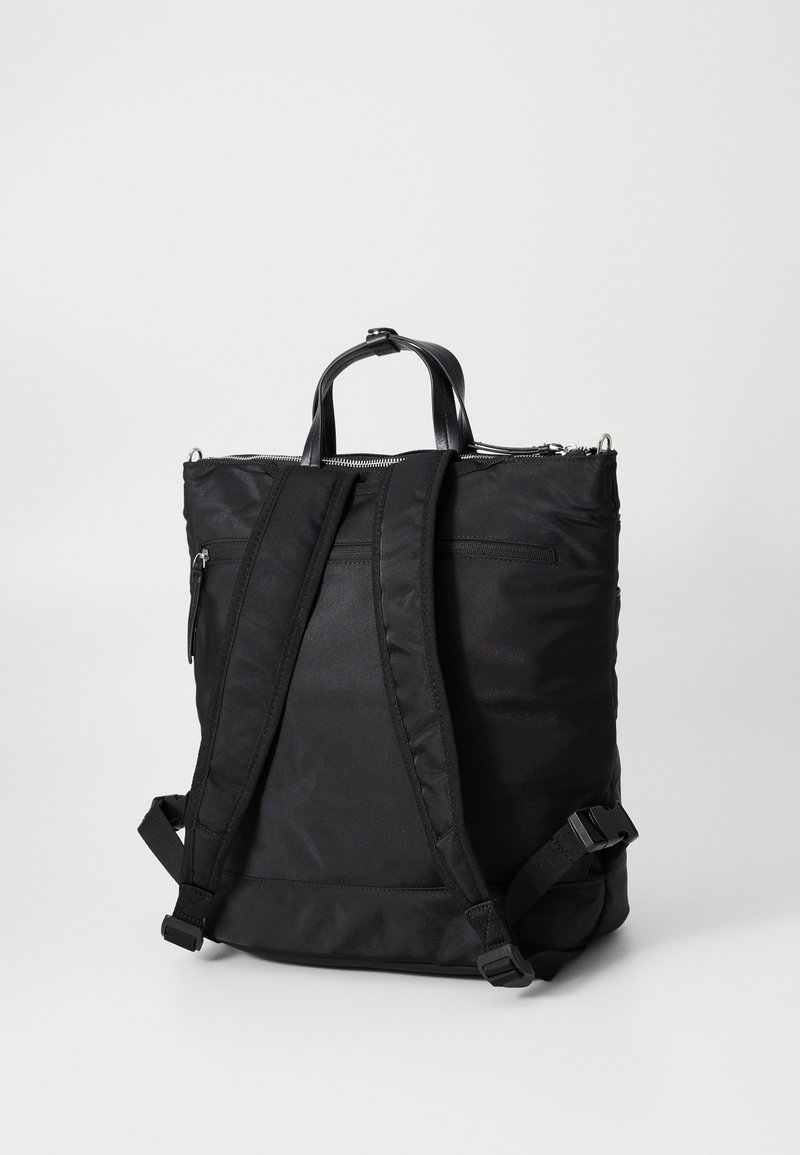 Zaino nero in nylon con due manici superiori, spallacci regolabili e un scomparto principale con zip; texture liscia e design minimalista.