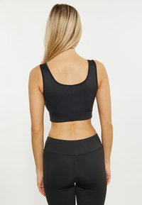 Zwarte sportieve crop top met een ronde halslijn, brede bandjes en een aansluitend ontwerp. Gladde textuur zonder zichtbare patronen of logo's.