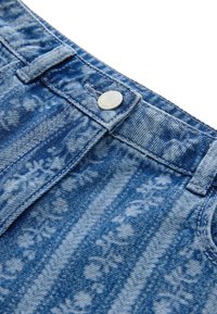 Sinine teksariidest kangas lillemustriga, millel on hõbedane nööp ja vööaasad. Iseloomulik tekstuur tuhmunud triipudega.