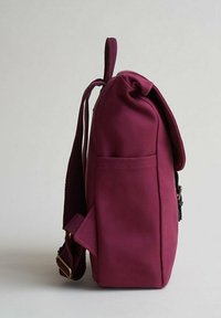 Bordeauxfärgad tygryggsäck med rundad topp, justerbar rem, sidoficka och enkel stängning. Texturerat material med en slät yta.