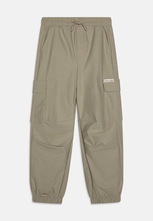 Lysebrune cargobukser med elastisk linning og manchetter, sidelommer og et lille Calvin Klein-logo på klappen af højre lomme.