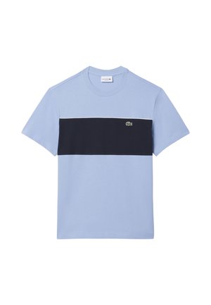 Maglietta a maniche corte azzurro chiaro con una larga fascia orizzontale nera sul petto e un piccolo logo verde a forma di coccodrillo sul lato sinistro.