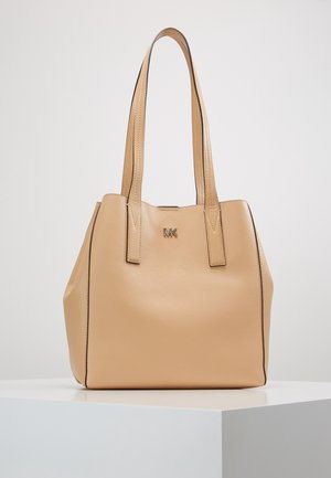 Beige Michael Kors-taske i læder med to skulderremme og lille gyldent "MK"-logo foran, vist på en hvid overflade.