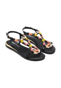 Sandalias negras con un patrón de cuentas único en rosa, amarillo y negro, con suela plana y diseño de tiras en el tobillo.