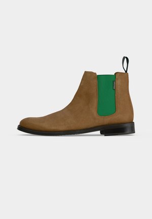 Bottine Chelsea en daim marron avec panneau latéral élastique vert et semelle noire, vue de côté extérieur sur fond uni.
