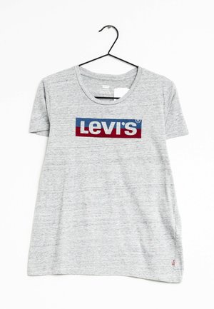 Maglietta grigia a maniche corte in tessuto morbido, con un rettangolo rosso e blu con il logo "Levi's" in bianco, appesa a un gancio nero.