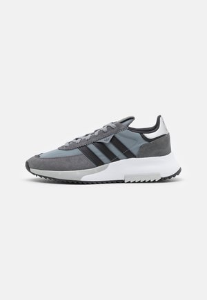 Gray and black athletic shoes with a suede and mesh upper, featuring three black stripes, a white midsole, and a textured rubber outsole.
