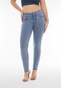 Slim jeans i ljusblå denim, med hög midja, knappstängning, sidofickor och en mjuk, något elastisk textur.