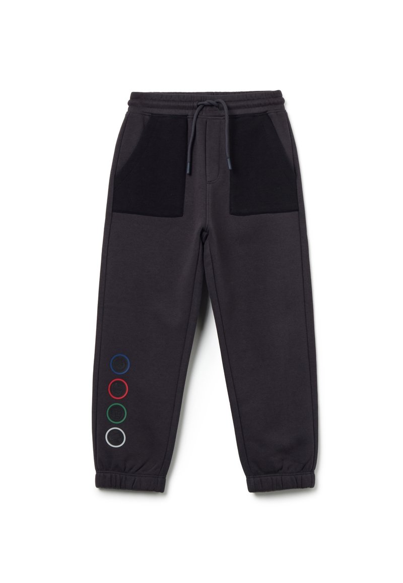 Donkergrijze sweatpants met zwarte zakken, een elastische tailleband en gekleurde cirkels in rood, groen, blauw en wit aan één kant.