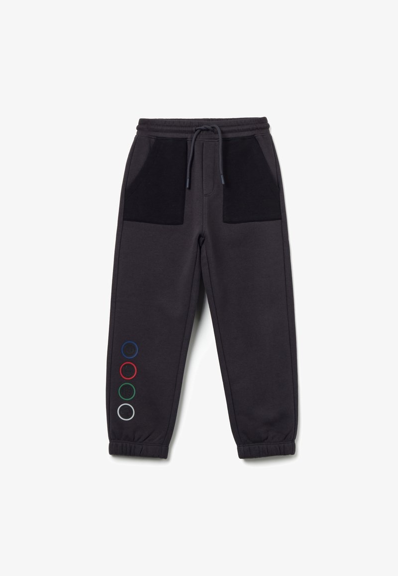 Donkergrijze sweatpants met zwarte zakken, een elastische tailleband en gekleurde cirkels in rood, groen, blauw en wit aan één kant.