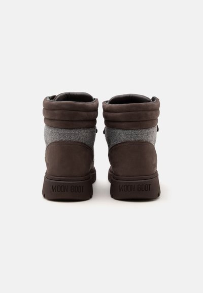 Paire de bottines d’hiver courtes en tissu marron et gris, vues de dos, avec "MOON BOOT" embossé sur la semelle.