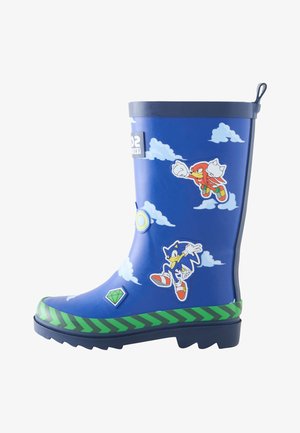 Siniset lasten kumisaappaat vihreällä siksak-kuviolla, koristeltu Sonic the Hedgehog- ja Knuckles-hahmoilla, pilvillä, vihreällä jalokivellä ja auringolla.